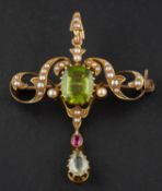 An Art Nouveau seed pearl, peridot, ruby and aquamarine pendant/ brooch,