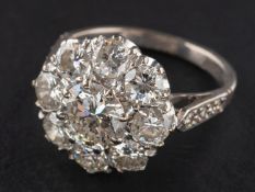 A round, brilliant-cut diamond cluster ring, estimated weight of principal diamond ca. 1.