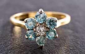 An 18ct gold, blue zircon and round, brilliant-cut diamond flower head ring,
