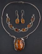 A oval amber necklace, bracelet and pair of earrings, with applied floral and foliate decoration,