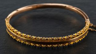 A late Victorian, 9ct gold, hinged bangle, with rope-work and ball decoration to borders,