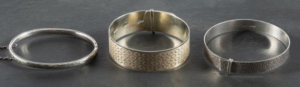 Three bangles, including a hinged bangle with engraved decoration, with hallmarks for Chester, 1960,