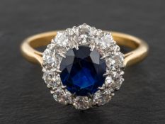 An oval, mixed-cut sapphire and round, brilliant-cut diamond cluster ring,