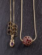 Two gemset pendants, including a spherical garnet set pendant, stamped '14K', diameter ca. 1.