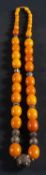 A graduated amber bead necklace, with ropework and foliate decorated spacers,