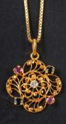 A quatrefoil, openwork ruby, sapphire and white paste pendant, stamped '875', length ca. 3.