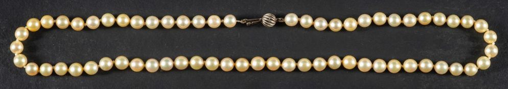 A single-strand necklace of cultured pearls, the pearls of yellowish hue with green overtones,