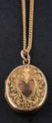 An oval locket pendant, with engraved with heart-shaped and foliate decoration, stamped '9CT',