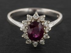 An 18ct gold, oval, mixed-cut ruby and round, brilliant-cut diamond cluster ring,