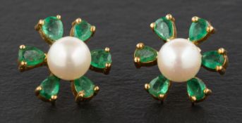 A pair of cultured pearl and pear-shaped emerald ear studs, of flowerhead design,