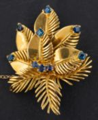 An 18ct gold, round, mixed and square step-cut sapphire floral brooch, with hallmarks for London,