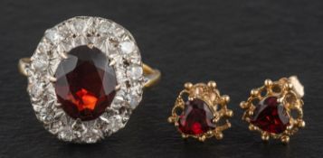 A garnet, single and round, brilliant-cut diamond cluster ring, total estimated diamond weight ca.