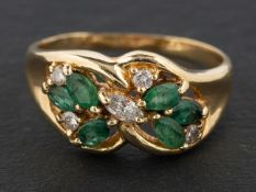 A round, brilliant and marquise-cut diamond and emerald ring, of floral design,