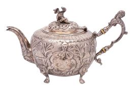 A chinoiserie design silver teapot, unmarked, bears crest and armorial, of circular outline,