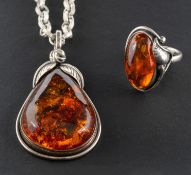A pear-shaped amber pendant and ring, with applied foliate decoration,