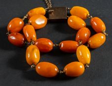 A two-strand, amber bead bracelet, diameter of beads ca. 9.5-12.2mms, total length ca. 19.