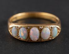 A cabochon-cut opal, half eternity ring with rose-cut diamond spacers, stamped '18CT',