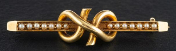 A Victorian seed pearl bar brooch with knot decoration, stamped '15C', length ca. 4.