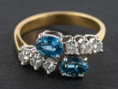 An 18ct gold, oval, mixed-cut probably synthetic sapphire and round,
