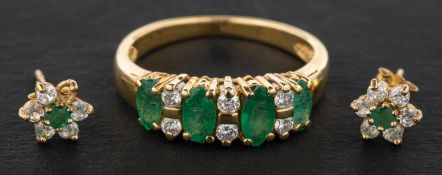 A marquise-shaped emerald, three-stone ring with round, brilliant-cut diamond spacers,