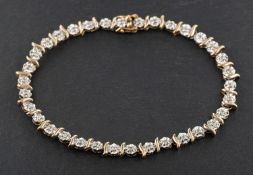 A 9ct bi-colour gold single-cut diamond line bracelet, according to engraving diamond weight 0.