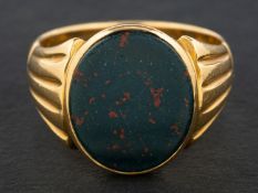 A bloodstone signet ring with reeded shoulders, stamped '18' and 'C.G', length of ring head ca. 1.