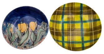 A white stoneware bowl by Warwick Parker painted with stylised tulips on a blue ground,