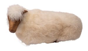 John Neusinger, a carved wood and sheepskin covered foot stool: as a recumbent sheep, 73cm long.