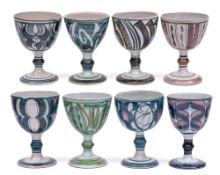 Aldermaston Pottery a group of eight terracotta goblets each with brushwork decoration,
