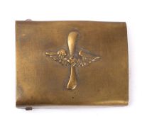 A German belt buckle, brass with winged swastika over a vertical propeller.