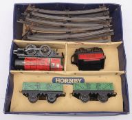 A Hornby O gauge post-war MO Goods Set: 0-4-0 loco and tender in red with two green wagons and