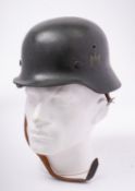 A German M1942 pattern Stahlhelm, dark green with remains of transfer to one side,