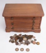 A small wooden coin cabinet containing mixed world coins: including 1812.