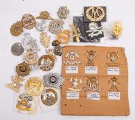 A collection of various regimental cap badges, including six lancer regiment badges and others.