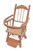 A child's beechwood elbow chair, the back with shaped top rail and spindle uprights,
