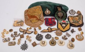 A collection of cap badges and insignia, including a Royal Marines green beret ,
