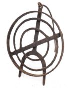 A circular wrought iron revolving grid iron with scrollwork designs and tripod feet, 31cm diameter,