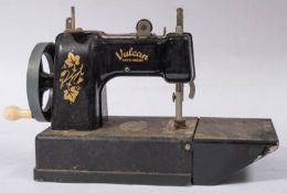 A Vulcan Tinplate toy sewing machine with remains of original box and a small trunk case.