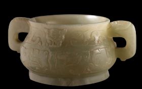 A small Chinese jade censer in archaic style of bombe form with mythical beast handles,