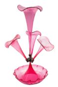 A cranberry glass epergne with central trumpet shape vase flanked by three smaller set on a shallow