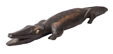A Trobriand Isles carved wooden crocodile inset shell eyes, 59cm long, dated to underside '1970'.