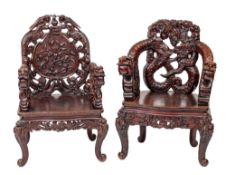 Two similar Chinese carved and stained hardwood elbow chairs,