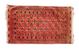 A Turkoman rug, the brick red field with two rows of quartered medallions,