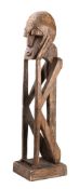 A large African carved softwood figure of a man seated with his head in his hands, 106cm high.