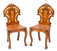 A pair of William IV or early Victorian oak hall chairs, circa 1840; each with arched, waisted,