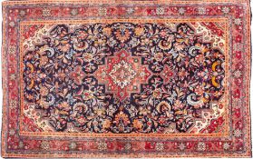 A Sarouk Rug, the indigo field with a central brick red stepped pole medallion,
