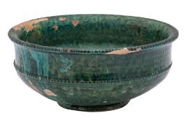 A Chinese green glazed pottery bowl with indented rim and beaded band below, possibly Tang Dynasty,