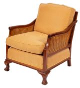 A mahogany and canework bergere, 20th century; the backrest with shaped toprail,