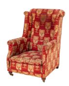 An upholstered wing armchair in Arts & Crafts style,