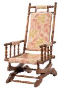 A turned beech and cotton upholstered rocking chair, possibly north American,